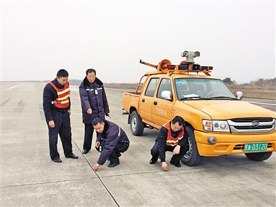 蒋基荣(左二)进行机场跑道巡查.